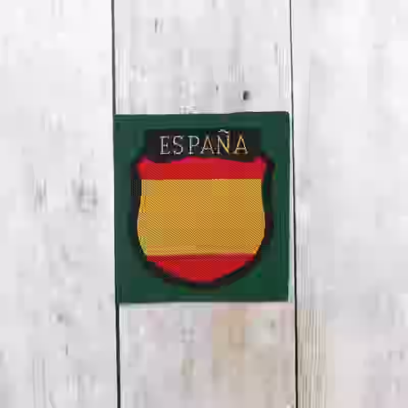 Spanish Division Volunteer Silk Woven Sleeve Shield - WWII-era Spanish Division volunteer silk woven sleeve shield with red and yellow embroidery on darkgreen background.