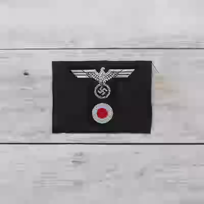 Panzer M42 Silk Woven Officer's Cap Insignia - WWII-era Panzer M42 officers’ silk woven cap insignia with silver eagle on dark grey wool.