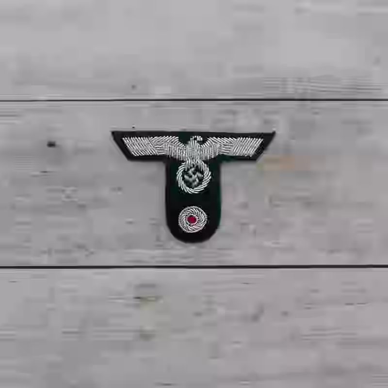 Gebirgsjäger Hand Embroidered Officer's Cap Insignia - WWII-era Gebirgsjäger officers’ hand-embroidered cap insignia with silver eagle on dark green wool.