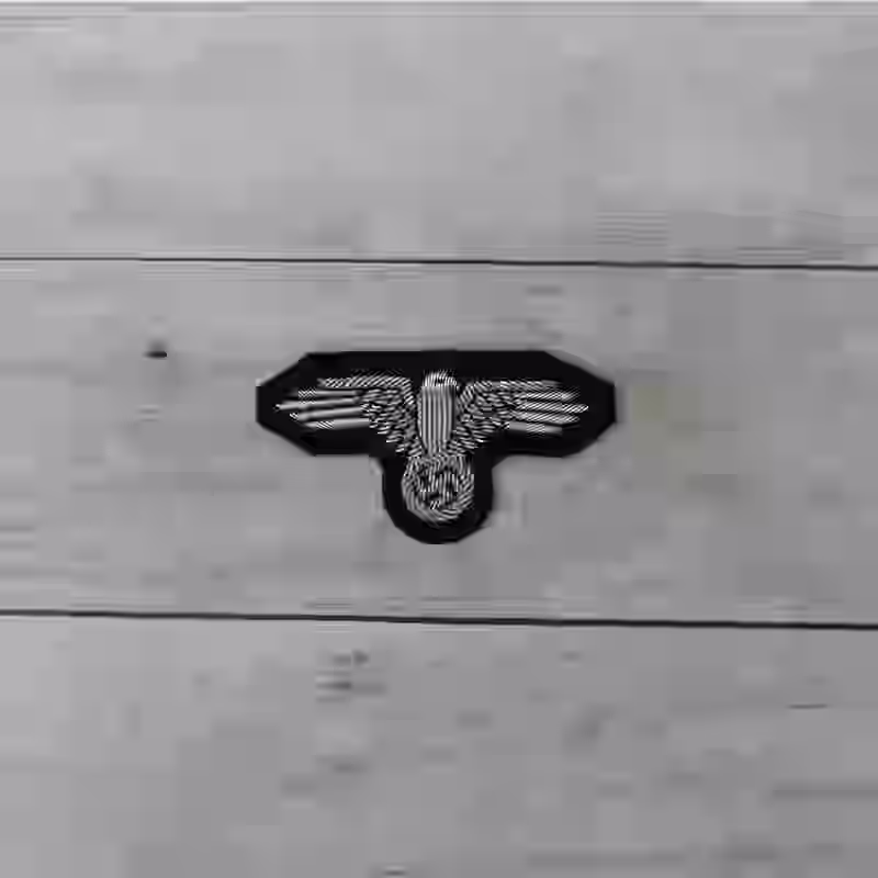 Waffen SS Officer's Hand Embroidered Cap Eagle - WWII-era Waffen-SS officers’ hand-embroidered cap eagle with silver thread on black wool.