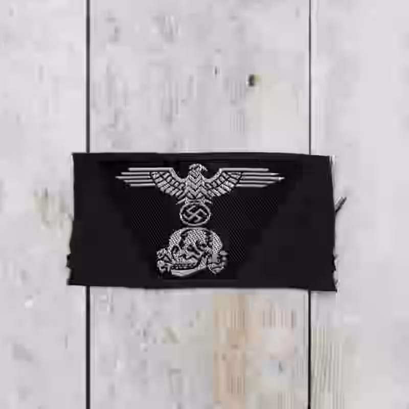 Panzer-SS Officers Woven Trapezoid Cap Insignia - WWII-era Panzer-SS officers woven trapezoid cap insignia with silver eagle and skull on black Be-Vo weave for M43 caps.