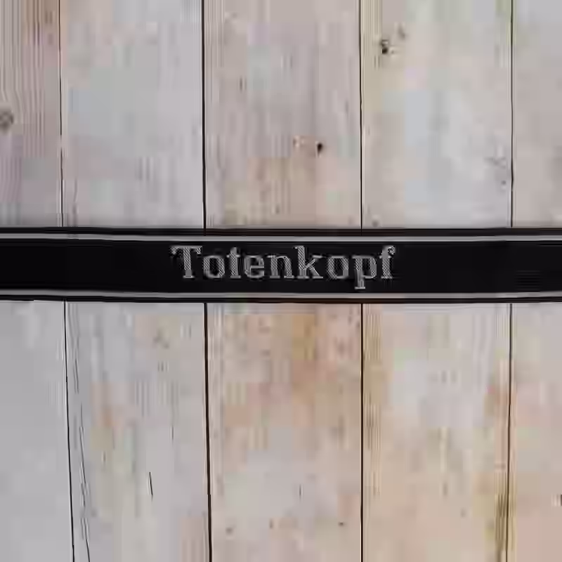 Totenkopf EM Cuff Title - WWII-era Totenkopf enlisted men’s cuff title with grey thread on black woven silk base in Be-Vo style for 3rd SS Panzer Division.