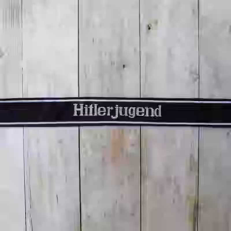 Hitlerjugend EM Cuff Title - WWII-era Hitlerjugend enlisted men’s cuff title with grey thread on black woven silk base for 12th SS Panzer Division.
