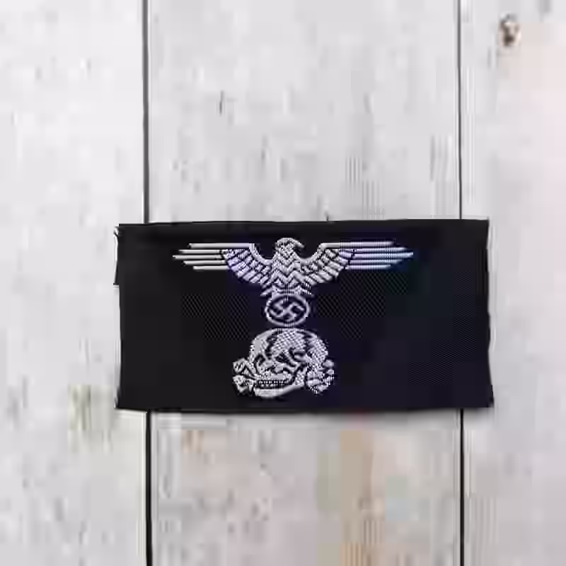 Panzer-SS Enlisted Men's Woven Trapezoid Cap Insignia - WWII-era Panzer-SS enlisted men’s woven trapezoid cap insignia with white eagle and skull on black Be-Vo weave for M43 caps.