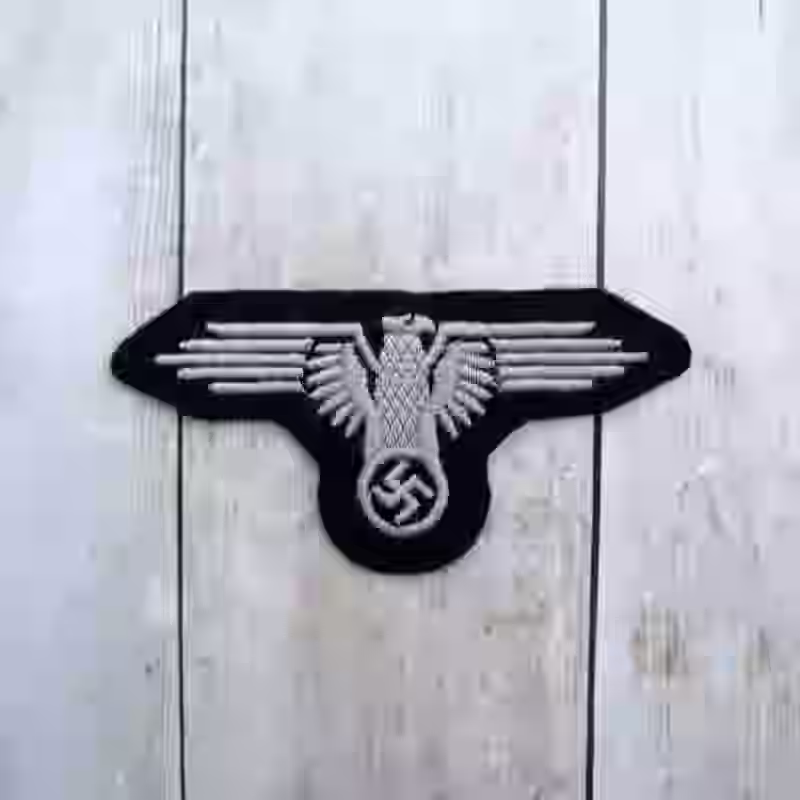 Waffen SS Enlisted Men’s Cloth Embroidered Arm Eagle - WWII-era Waffen SS enlisted men’s cloth embroidered arm eagle with white thread on black fabric base for uniforms from 1934 onward.